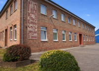 Geb&auml;ude mit roten Backsteinen und Fensterfronten