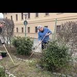 zwei Personen mit Harke und Hacke bei der Gartenarbeit auf einem Beet Gartenarbeiten